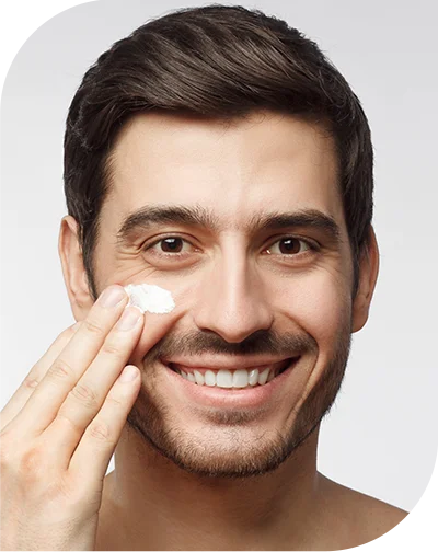 a guy rubbing cream on his face